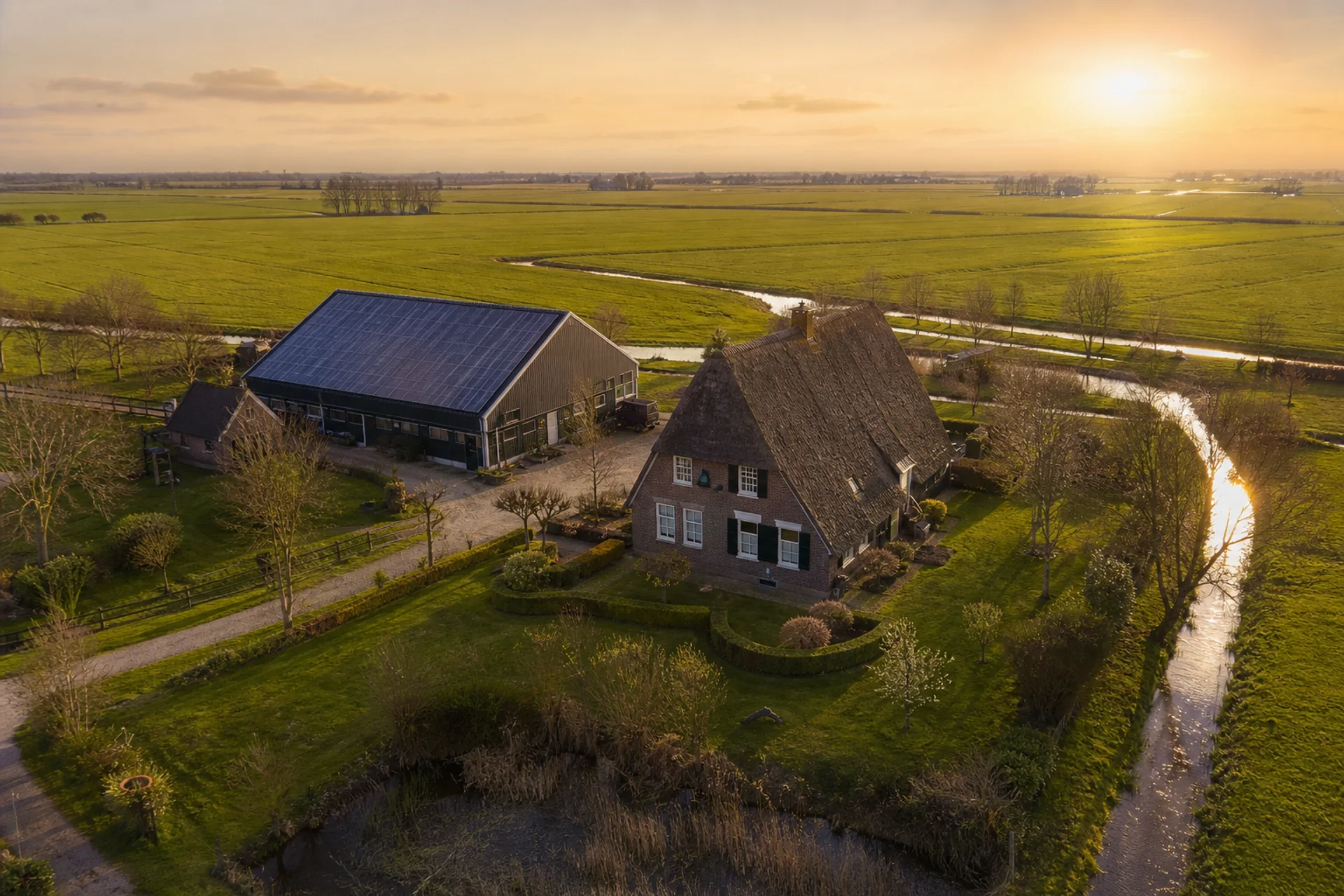 Nederlandse boerderij met zonnepanelen, luchtfoto bij avondlicht